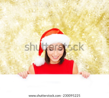 christmas, x-mas, people, advertisement and sale concept - happy woman in santa helper hat with blank white board over yellow lights background