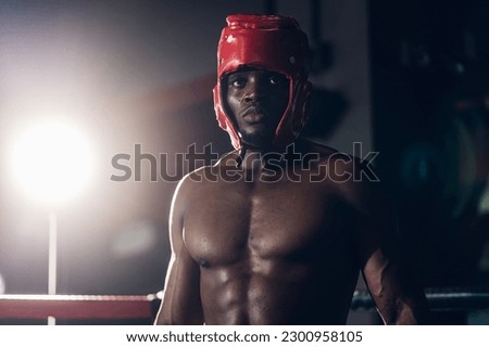 Boxer preparing for training in Boxing Club. Confident boxer standing in pose and ready to fight. Boxing fighters training at gym