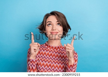 Photo of pretty lady directing fingers up empty space advertising novelty product wear print shirt isolated blue color background