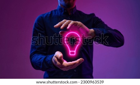 Neon colored light bulb between male hands. Businessman generating innovative, creative, profitable ideas, project, startup. Concept of technologies, data science, programming, business, brainstorming