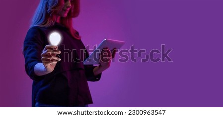 Young girl working on laptop, holding lightbulb symbolizing innovative ideas, project development, startup launching. Concept of modern technologies, data science, programming, business, brainstorming