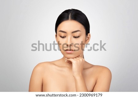 Double Chin Prevention. Upset Asian Woman Touching Her Face Skin Concerned About Antiage Skincare Treatment Over Light Gray Background. Skin Care Challenges And Beauty Imperfections Royalty-Free Stock Photo #2300969179