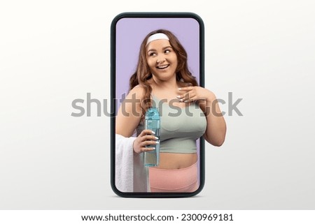Smiling young caucasian lady plus size in sportswear with bottle of water on big smartphone screen isolated on white studio background. Body care app, blog for weight loss and fit