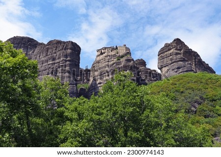 Meteora mountains with the Monastery of St. Varlaam at the top of the rocky cliff in the middle, central Greece, Eastern Orthodox religion, tourism destination, blue sky, copy space, selected focus