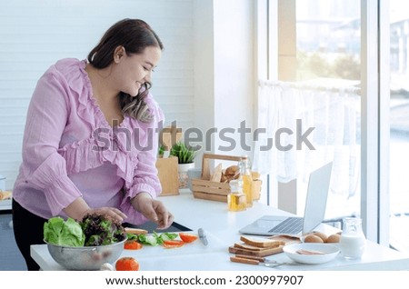 Fat woman are determined to lose weight, by learning to cook healthy food from video clips on the laptop, eating concept for weight loss and health