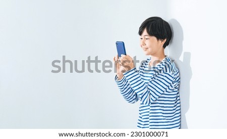 Asian boy using a smart phone. Royalty-Free Stock Photo #2301000071