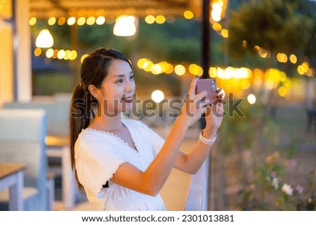 Woman use mobile phone to take photo in city