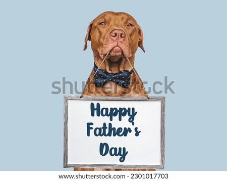 Happy Father's Day. Cute brown puppy and an inscription with words of love for Dad. Closeup, indoors. Studio photo. Congratulations for family, loved ones, friends and colleagues. Pets care concept