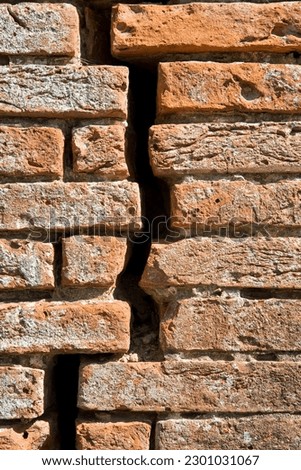 Dangerous old exposed brick wall with deep crack due to structural foundation failure, soil subsidence, corrosion and deterioration of building materials, Climate and seasonal changes, earthquake  Royalty-Free Stock Photo #2301031067