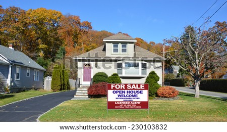 Real Estate For Sale Open House Welcome sign on front yard lawn of suburban bungalow style home residential neighborhood clear blue sky USA