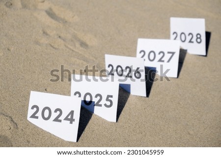 Paper cards with numbers of years from 2024 to 2028 in a row. New year start concept. Resolution time is flying plan goal motivation