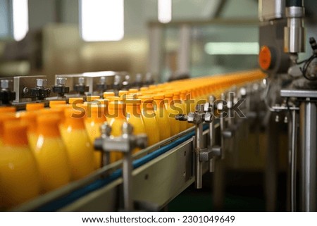 Orange juice factory. Robotic factory line for processing and bottling of orange juice bottles. Selective focus.