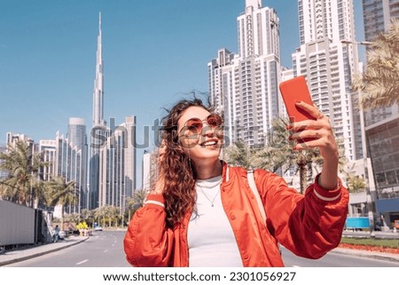 Tourist happy girl taking photos for her travel blog, in Dubai