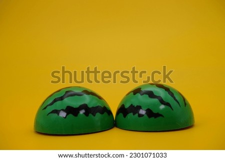 toy watermelon cut isolated yellow background. Watermelon toys that can be installed and removed.