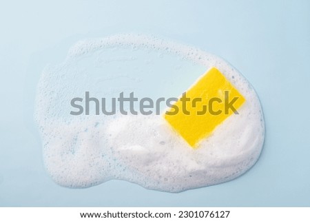Cleaning sponge and a soapy foam on a blue background. Cleaning concept, cleaning service. Banner. Flat lay, top view Royalty-Free Stock Photo #2301076127