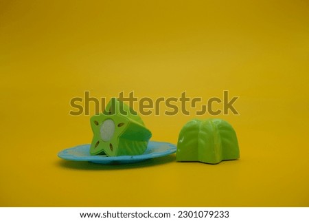 toy star fruit and blue plate isolated on yellow background. starfruit toys that can be installed and removed.