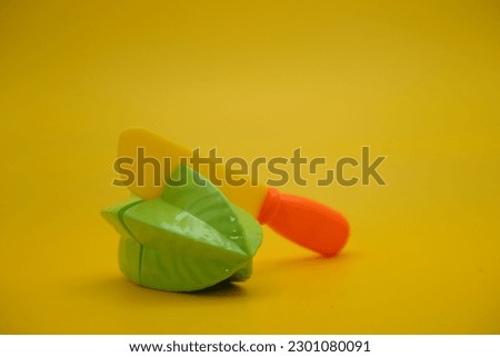 toy star fruit and knife isolated on yellow background. starfruit toys that can be installed and removed.