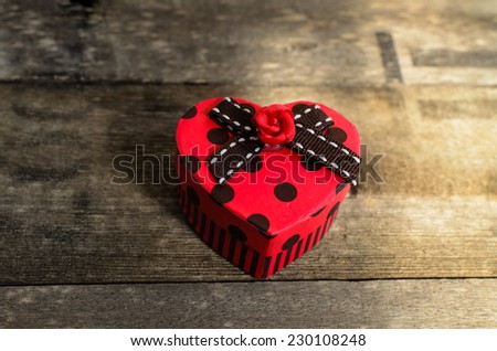 Still light Red heart box shape on grunge wooden background, nature light.