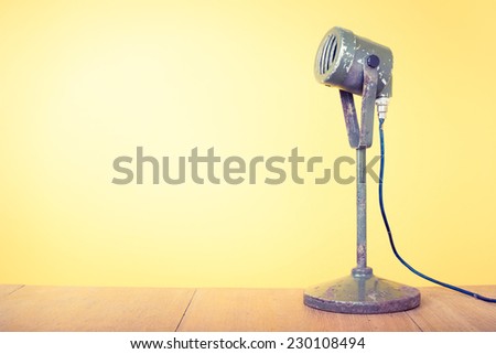 Old retro microphone front yellow background