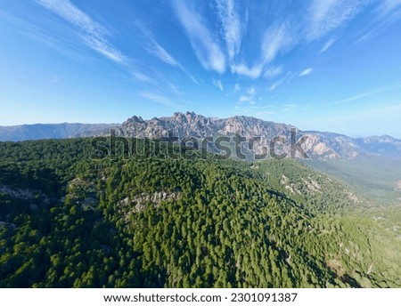 Aerial Panorama of Aiguilles de Bavella: Majestic Peaks, Misty Valleys, and Endless Forests in Corsica's Enchanting Landscape