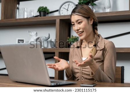 Young woman use laptop computer making video call  or online meeting to presentation her work, She smile and talking with cheerful, copy space