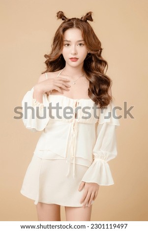 Young Asian beauty woman curly long hair with korean makeup style on cute face and perfect skin on isolated beige background. Facial treatment, Cosmetology, plastic surgery.