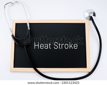 A stethoscope ang blackboard written of heat stroke. Isolated with white background.