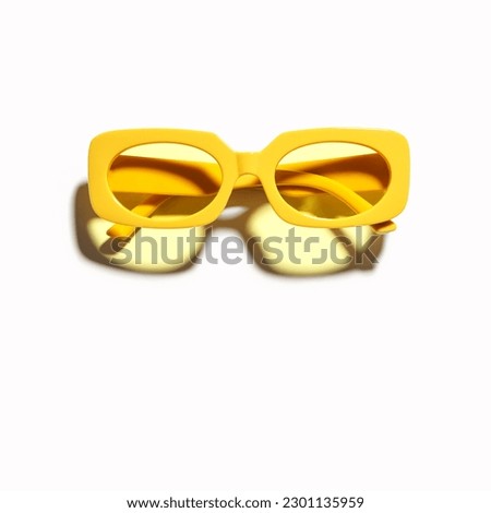 Stylish yellow sunglasses with transparent yellow glass isolated on white background, shadow from sunlight, summer fashion plastic-framed glasses. Summer sale concept. Top view eyeglasses photo Royalty-Free Stock Photo #2301135959