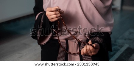 Muslim woman in hijab praying on mat indoors, Muslim woman praying isolated on black background Royalty-Free Stock Photo #2301138943