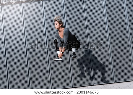 Woman athlete jumping during her high-intensity interval training on the street. Royalty-Free Stock Photo #2301146675