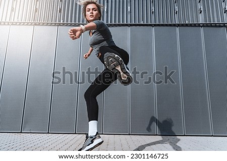 Woman athlete jumping during her high-intensity interval training on the street. Royalty-Free Stock Photo #2301146725