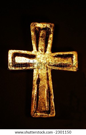 Close-up of golden cross with decoration against black background