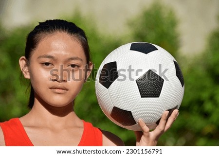 Unemotional Filipina Person With Soccer Ball Royalty-Free Stock Photo #2301156791
