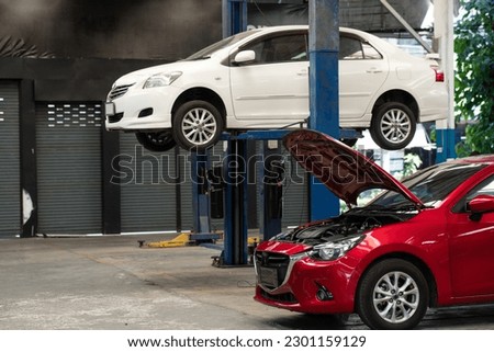 Background of the lifted car waiting for repair in motor service at the auto repair shop. Repair vehicle career Royalty-Free Stock Photo #2301159129