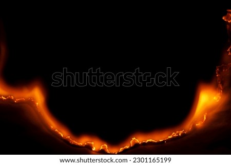 burning paper, glowing edge of paper on a black background Royalty-Free Stock Photo #2301165199