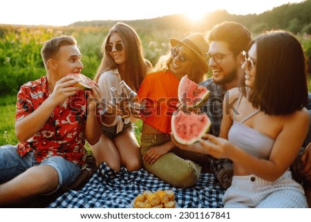 Happy groop of friend resting in nature in the picnic. People, lifestyle, relaxation and vacations concept.
