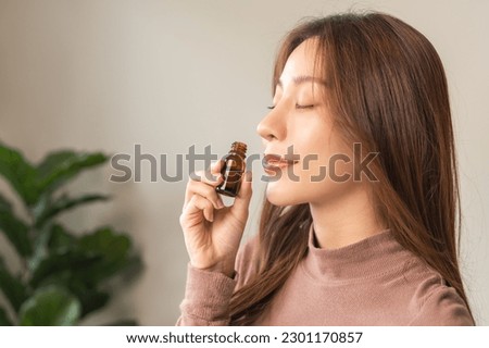 Aromatherapy, attractive asian young woman, girl face expression enjoying smell fragrance of herbal from medicine natural organic essential perfume oil at home. Therapy treatment, beauty skin care. Royalty-Free Stock Photo #2301170857