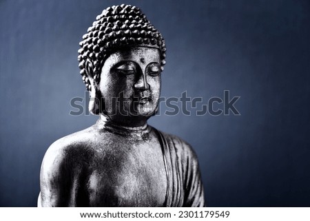 Meditating Buddha Statue on dark background. Soft focus. Close up. Copy space.                                                               