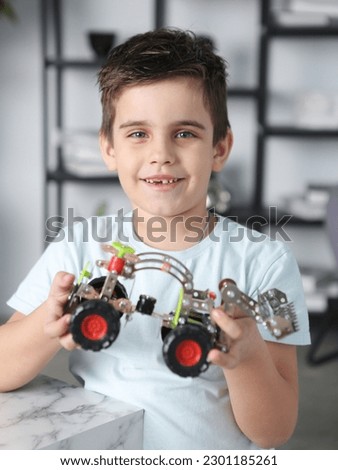 little preteen boy play with steel mechanical constructor set close up photo. High quality photo