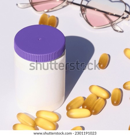 white plastic bottle with pills and sunglasses on white background. template, mock up concept. copy space. sun protection and sunscreen supplements