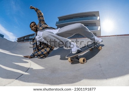 Surf skater performing a agressive slide on a skatepark during a sunny day. Royalty-Free Stock Photo #2301191877