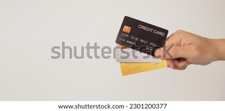 Hand is hold three credit cards. Black gold and silver color credit cards isolated on white background. Royalty-Free Stock Photo #2301200377