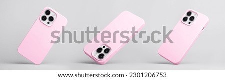 set of three iPhone 13 Pro and 14 in pink silicone case falling down in different angles, back view isolated on grey background, phone case mockup