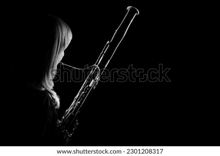 Bassoon woodwind instrument player. Classical musician woman playing orchestral bass. Wind instruments Royalty-Free Stock Photo #2301208317