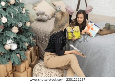Mother and child hold photo canvas in the interior Christmas