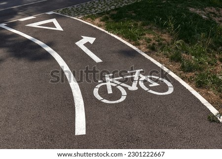 Bicycle lane sign on asphalt surface with turning arrow