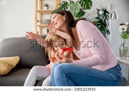 Smiling mother got a present from her cute little daughter Royalty-Free Stock Photo #2301223931