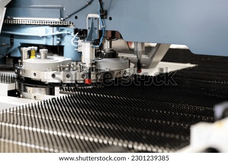 Industrial CNC turret punching machine close up. Selective focus. Royalty-Free Stock Photo #2301239385