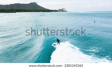 Surfer riding a wave in Hawaii Royalty-Free Stock Photo #2301245565