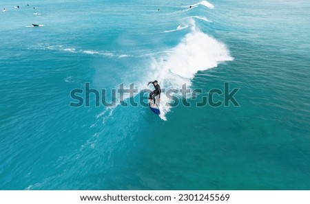 Surfer riding a wave in Hawaii Royalty-Free Stock Photo #2301245569